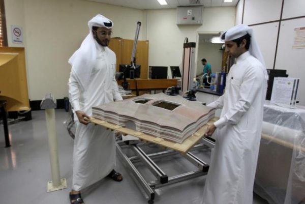 Mechanical engineers Abdullah Mojeb Aldar (L), 26, and Fahad al-Musalam, 24, move a 3d-printed model of QatarÕs Al Bayt stadium, which will host a World Cup semi-final in 2022, at a laboratory at Qatar University in Doha, Qatar June 16, 2016. REUTERS/Ibraheem Al Omari